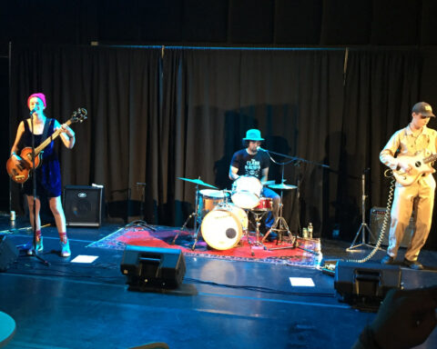 Photo of the rock band, Yolk Bath, performing on stage.