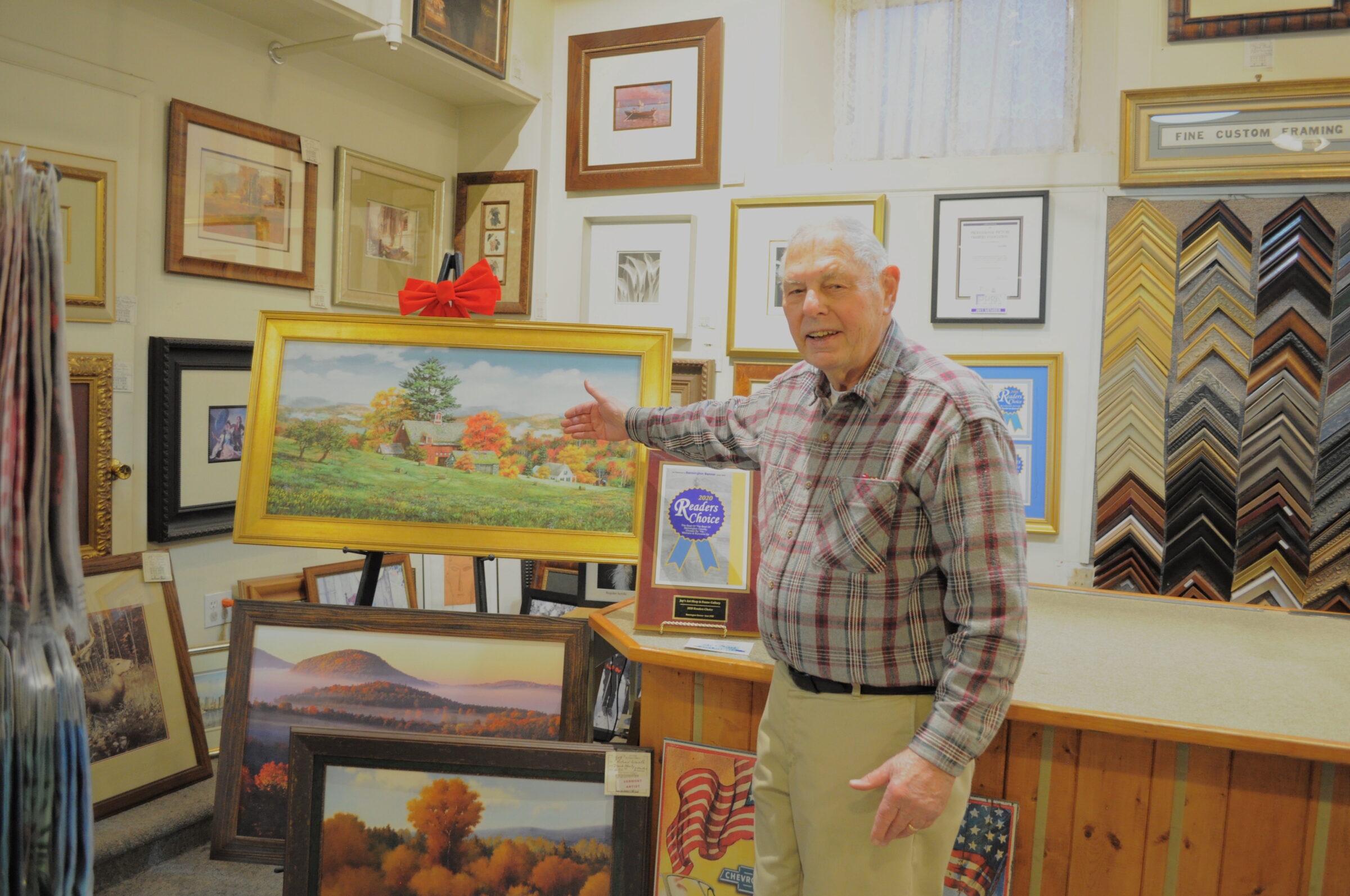 Photo of an elderly man, Jay Zwynenburg, standing inside the picture framing section of an art supply store.
