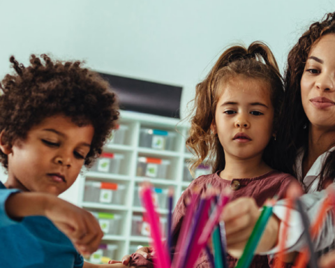 Pre-school teacher working with three young children.