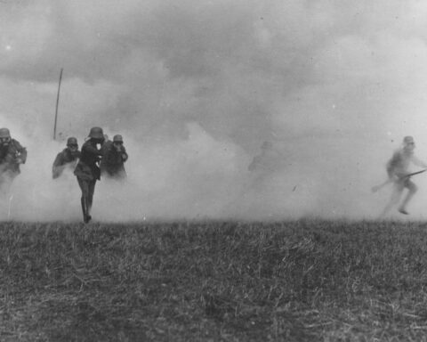 Exterior medium distant photo of soldiers fleeing a mustard gas attack in Flanders, France during WWI