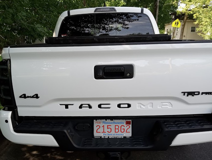 Close-up, rear view of a white pickup truck.